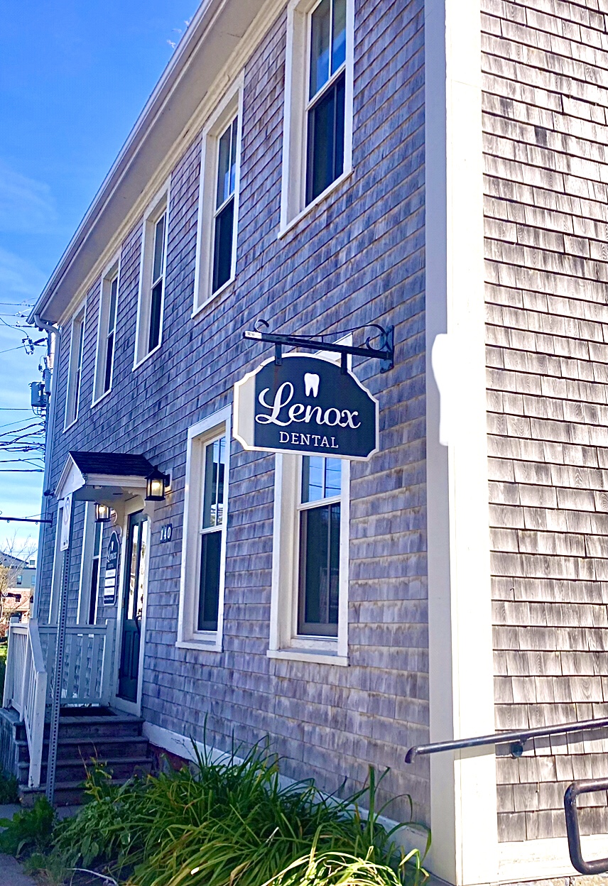 The hanging Lenox Dental sign on the shingled side of the building